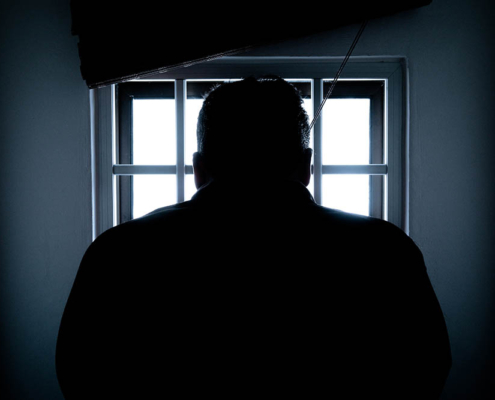 silhouette of a man in window mediano