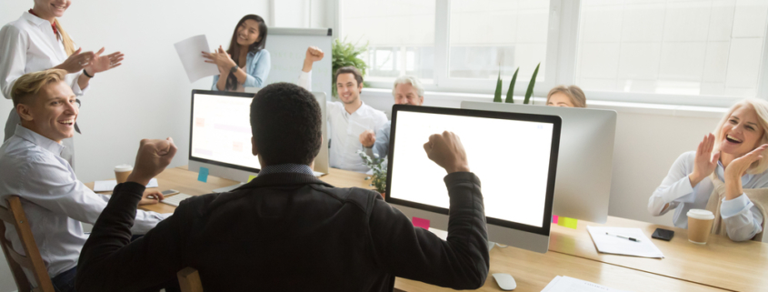 diverse colleagues congratulating black coworker with good result or win